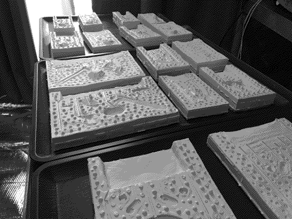 A row of plastic cast-style molds for building components of the Doppelganger figure.