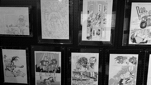 A closeup of the gallery wall focusing on pages from the first volume of the re:BOMBOM reprint of the Devil Children manga.
