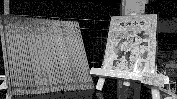 A closeup of a shelf with copies of Hideaki Fujii's Bomber Girl.