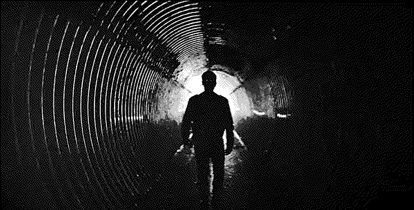 The shadow of a man walking within a pipeline.