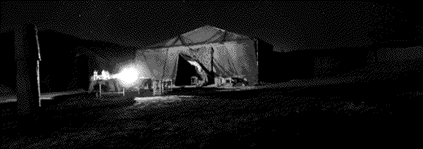 A large tent on the desert illuminated by a single flame.